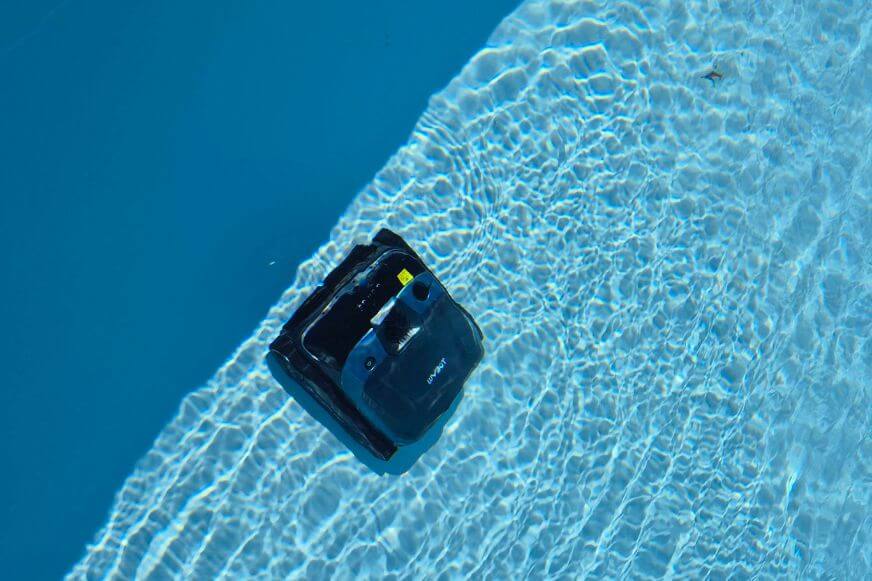 WYBOT S3 Poolroboter bei der Wandreinigung von oben. Der Roboter navigiert entlang der Poolwand im Einbaupool.